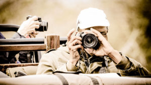 man holding a camera on a photographic safari