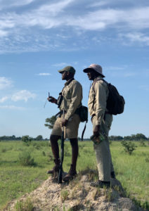 Two-rangers-standing-on-termite-mound-in-the-Okavango-Delta