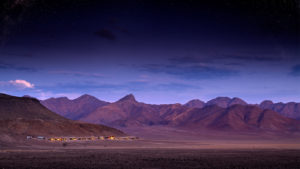 Remote Sossusvlei Desert Lodge surrounded by mountainous backdrop and night sky