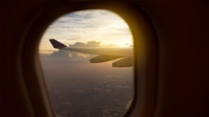 View out of airplane window seat at sunset