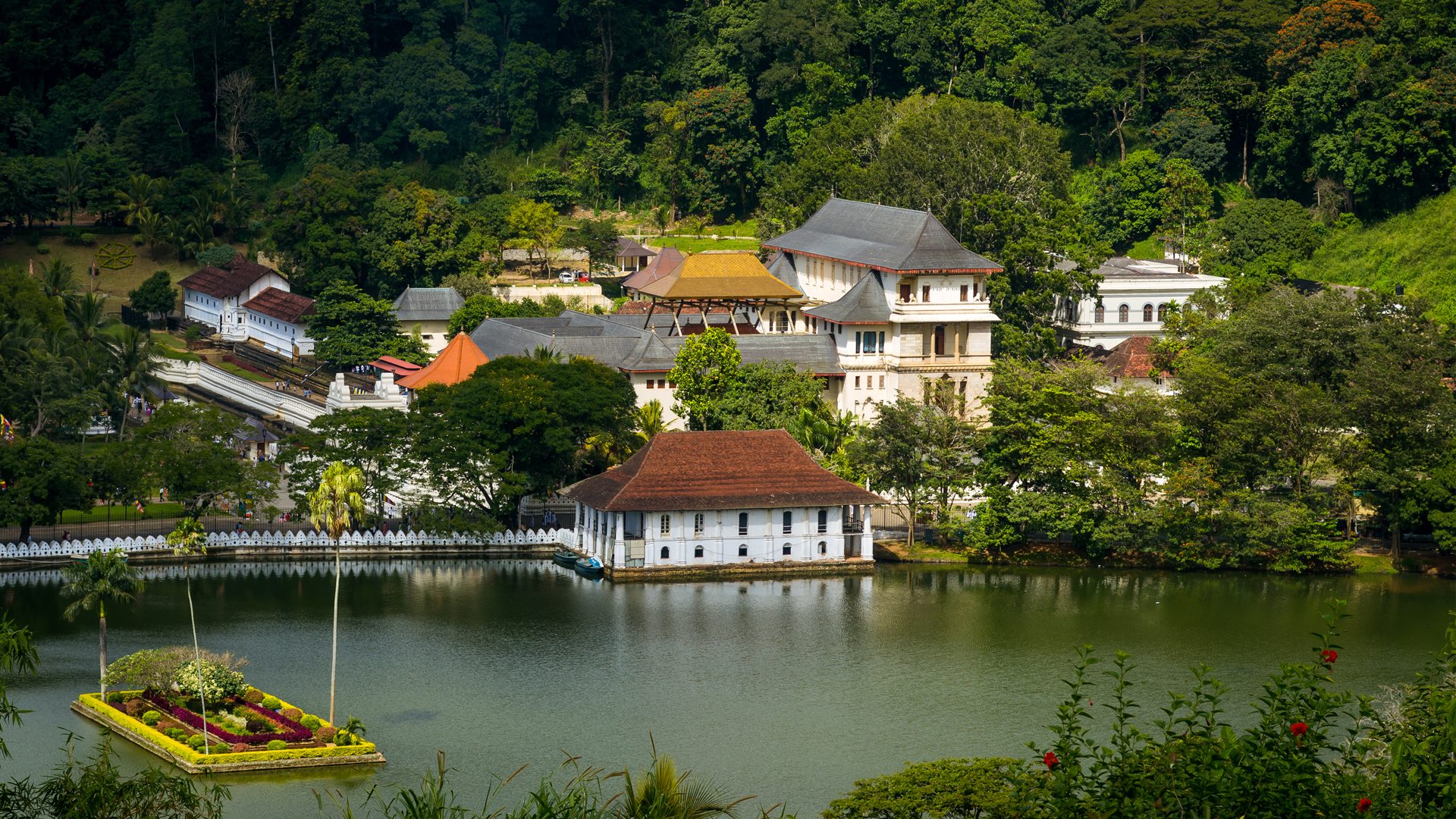 Scenic view of the Temple of the Sacred Tooth Relic complex situated on Kandy Lake, illustrating a crucial element of kandy travel.
