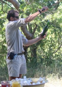 andbeyond guide jarryd du preez sabering a bottle of champagne