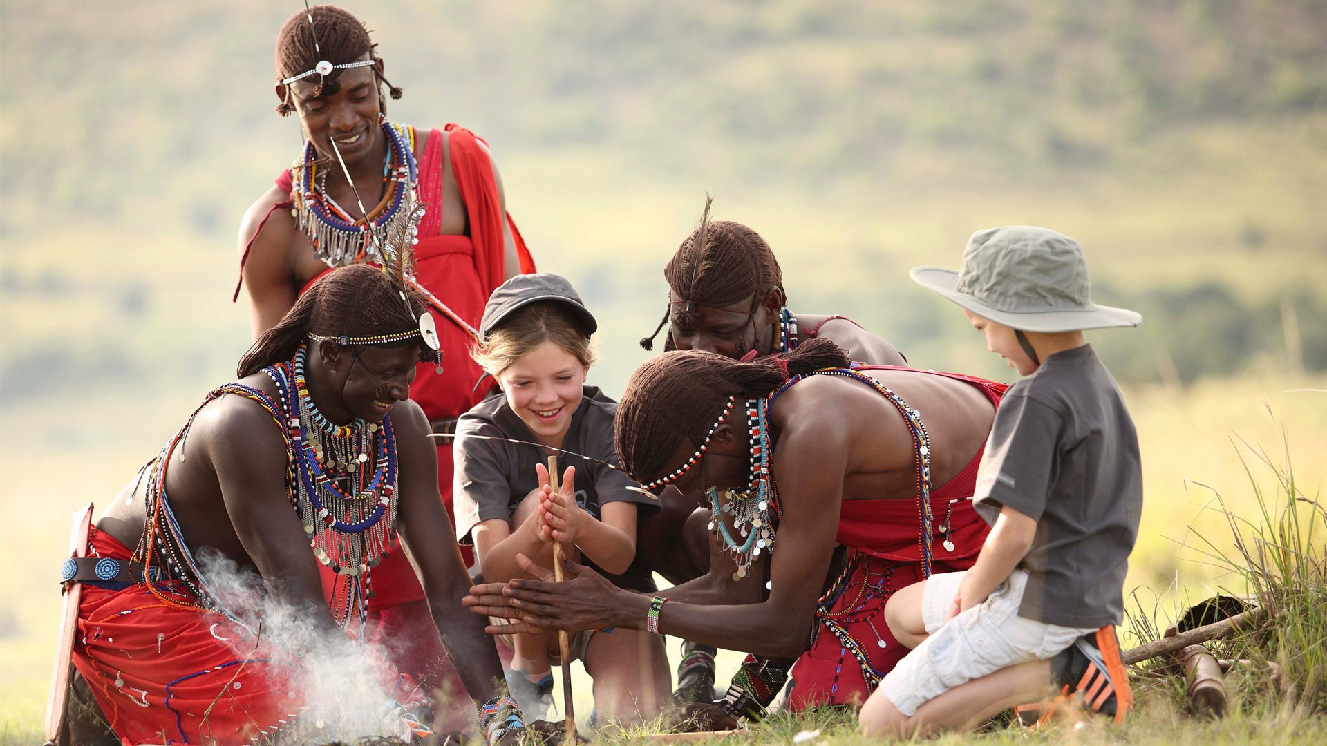children learning to make fire with sticks by maasai men in wildchild programme